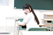 Student seated in classroom long hair looking over her shoulder
