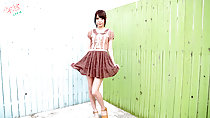 Ayana standing in back yard painted fences wearing brown dress in high heels