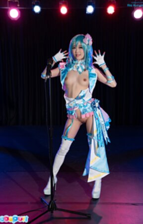 Ria Kurumi standing at microphone lowering her panties
