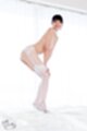 Leaning forward hands on knees wearing white stockings high heels