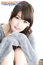 Seated with legs drawn up hands clasped on her knees in sweater