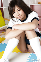 Sitting on floor arms folded across her knees shorts around thigh neat trimmed pussy