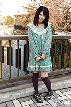 Standing in garden wearing dress hands together at her waist wearing socks