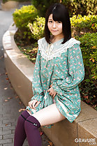 Mai Araki seated on wall lifting hem of her dress over her thigh