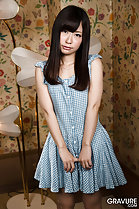 Standing in gingham dress long hair hands at her front