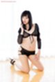 On her knees in sheer black outfit hand resting on thigh
