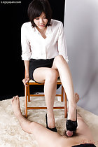 Office lady in white short and black skirt wearing high heels seated on chair giving footjob