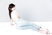 Seated in jeans long hair in ponytail in jeans bare feet