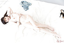 Lying on her back bare breasts wearing panties
