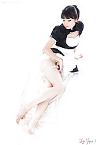 Anna Matsuda seated in French maid uniform pulling her panties down bare feet