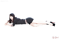 Lying on her side wearing business outfit in high heels
