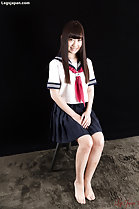 Kogal seated with hands clasped on her lap bare feet