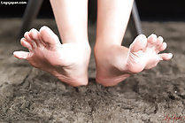 Raising her bare feet stretching her toes
