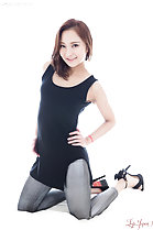 Kneeling with hands on hips wearing jeans in high heels