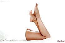 Lying on her front bare feet raised