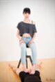Seated on stool wearing jeans hands on thighs hard cock between her bare feet