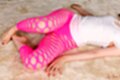 On her back in white top wearing leggings