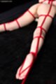 On her front nude tied up with rope