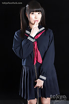 Wearing uniform finger raised to her lips in bondage chain
