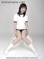 Kogal seated in gym class uniform knees pressed together