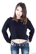 Standing with hands on hips wearing black sweater in jeans
